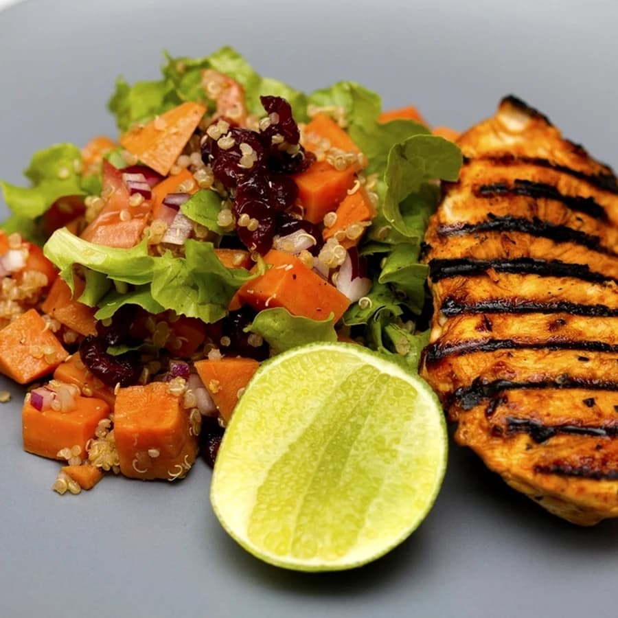 A grilled chicken salad plate with quinoa and lime, representing a personalized meal plan